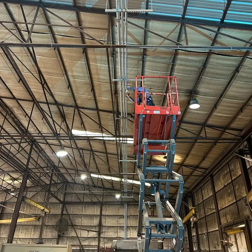 Running conduit across the ceiling of a steel plant in Hurst